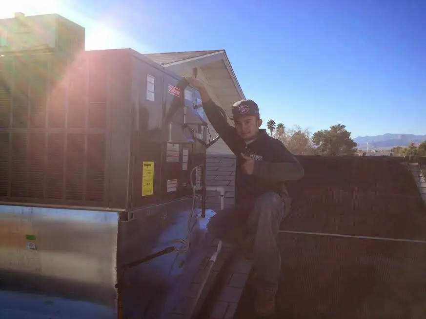 HVAC technician performing Heat Pump Repair on a rooftop unit in Locust Grove